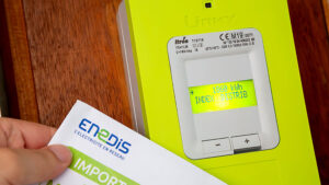 Benon - France - 21 February 2020 - Hand holding the opening contract for a linky box ERDF (Electricity Network Distribution France) in the entry of Building